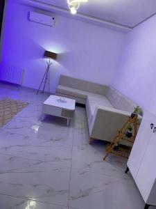 ein weißes Zimmer mit einem Bett und einem Tisch in der Unterkunft Charming apartment in Ariana