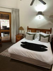 a bedroom with a bed with a black robe on it at Kruger Park Lodge Unit No. 543 in Hazyview +37 photos