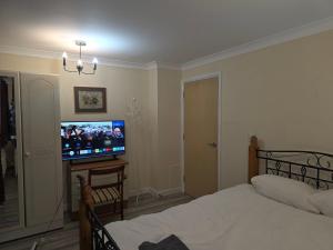 a bedroom with a bed and a flat screen tv at Colchester CO1 Hythe Ta in Hythe