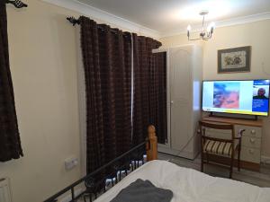 a bedroom with a bed and a flat screen tv at Colchester CO1 Hythe Ta in Hythe