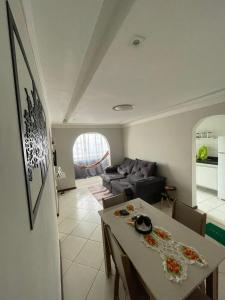 uma sala de estar com uma mesa e um sofá em Apartamento aconchegante próximo a praia em Ilhéus