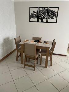 uma mesa de jantar com cadeiras e um computador portátil em Apartamento aconchegante próximo a praia em Ilhéus