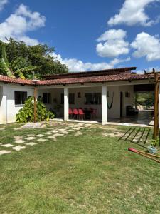 ein Haus mit roten Stühlen im Hof in der Unterkunft Summer House in Jijoca de Jericoacoara
