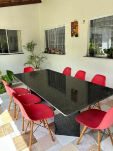 einen Konferenzraum mit einem schwarzen Tisch und roten Stühlen in der Unterkunft Summer House in Jijoca de Jericoacoara + 32 Fotos
