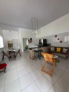 eine Küche und ein Wohnzimmer mit Tischen und Stühlen in der Unterkunft Summer House in Jijoca de Jericoacoara