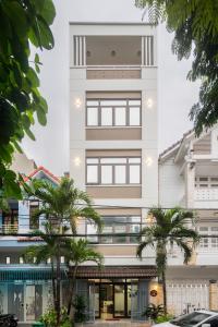 a building with palm trees in front of it at AnhHouse85 Da Nang - 750 meters from the beach - Free airport pick up and free modern coffee machine provided in Da Nang
