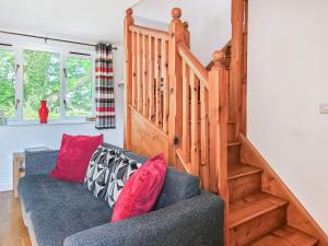 a living room with a couch with red pillows at Stabl-Oh4 in Dihewid
