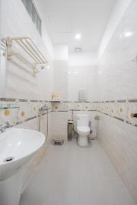 a white bathroom with a sink and a toilet at AnhHouse85 Da Nang - 750 meters from the beach - Free airport pick up and free modern coffee machine provided in Da Nang +110 photos