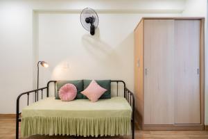 a bedroom with a bed with pillows and a fan at AnhHouse85 Da Nang - 750 meters from the beach - Free airport pick up and free modern coffee machine provided in Da Nang