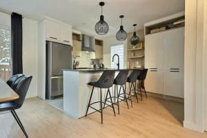a kitchen with a island with bar stools in it at Chalet Athena in Pont-Rouge