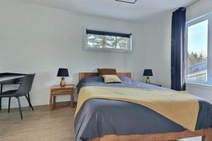 a bedroom with a bed and a desk and a window at Chalet Athena in Pont-Rouge +22 photos