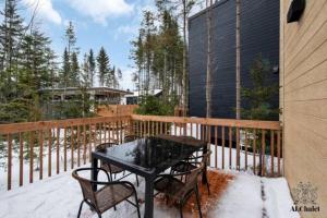 a table and chairs on a balcony in the snow at Chalet Athena in Pont-Rouge