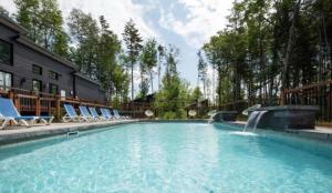 a swimming pool with chairs and a water fountain at Chalet Athena in Pont-Rouge
