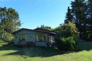 a small shed with a table and a bench in a yard at 11825-Nykobing-Sj-Bakkelodden-1 in Nyrup
