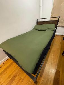 un letto con piumone verde su un pavimento in legno di Union Square Studio with Kitchen -Shared Bathroom a New York