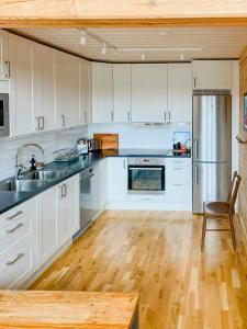 een keuken met witte kasten en een roestvrijstalen koelkast bij Mountain-Close Cabin With Panoramic View in Stöten