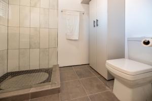a bathroom with a toilet and a shower at Port Owen Marina by First Private Stays in Velddrif