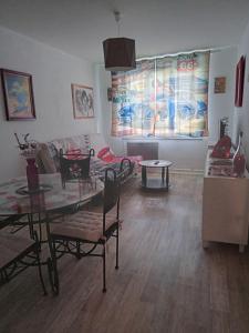 ein Wohnzimmer mit Tisch und Couch in der Unterkunft Appartement le labyrinthe du peintre in Bransat + 11 Fotos