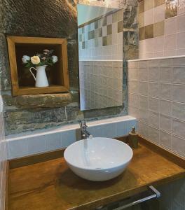 ein Badezimmer mit Waschbecken und einer Blumenvase in der Unterkunft Casa La Ribera in Lon