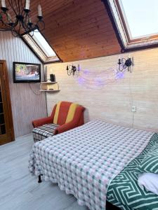 スラブスクにあるНа Двоїхのベッドと椅子とテレビのある寝室