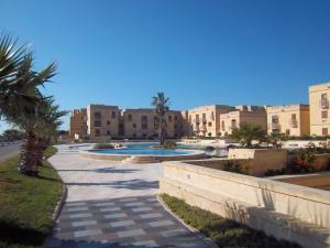 a resort with a swimming pool and buildings at Luxury apartment - Fort Chambray in Għajnsielem