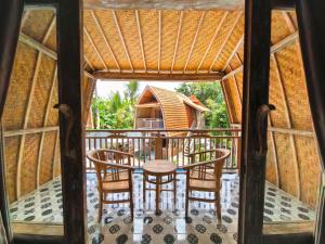 a room with a table and chairs on a porch at Brady's Ubud Villas in Ubud