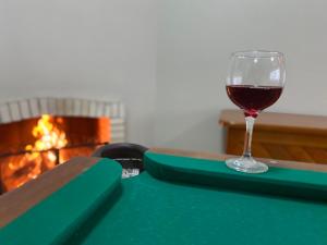 a glass of wine sitting on a table next to a fireplace at Letto Hotel Candeeiro da Serra in Salvador do Sul +53 photos