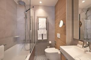 a bathroom with a tub and a toilet and a sink at Hôtel de Sévigné in Paris +50 photos
