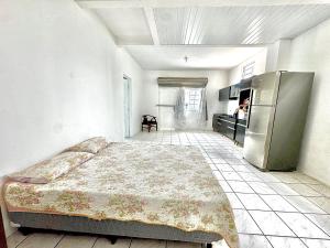 Un dormitorio con una cama y un frigorífico. en Estudio confort Serraria, en São José