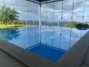 a view of a swimming pool with glass walls at Letto Hotel Candeeiro da Serra in Salvador do Sul