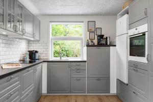 a kitchen with gray cabinets and a window at LF16121-Farso-Bjarkesvej-11 in Farsø +19 photos