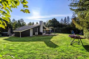 a small house with a playground in the yard at LF16121-Farso-Bjarkesvej-11 in Farsø