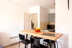 サン・フロランにあるCasa San Roccuのキッチン(木製テーブル、黒い椅子付)