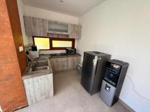 a small kitchen with a refrigerator and a sink at Villa Leyan 1 Semer - Between Seminyak & Canggu in Seminyak