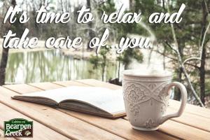 a cup of coffee and an open book on a table with a book at Rustic and Romantic Cabin with Breakfast Included near Royse City, Texas in Quinlan +4 photos