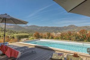 a swimming pool with an umbrella and chairs next to it at Villa Davia in Corbara