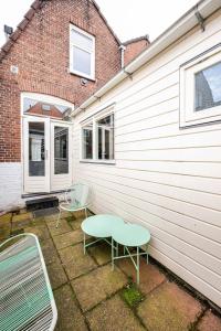 two chairs and a table in front of a house at The Alkmaar Family House in Alkmaar