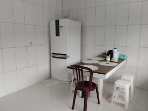 a kitchen with a table and a white refrigerator at Quarto 1 próximo ao Aeroporto Internacional in Belém