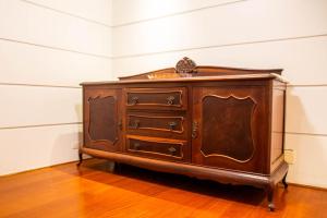 eine hölzerne Kommode in einem Zimmer in der Unterkunft Book Santos SaintClaude 100 metros quadrados no Coração de Santos in Santos + 37 Fotos