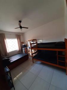 a room with two bunk beds and a ceiling fan at Linda Casa de Praia com Piscina em Itapoá in Itapoa