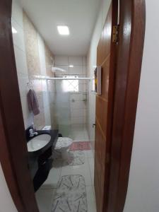 a bathroom with a sink and a toilet at Linda Casa de Praia com Piscina em Itapoá in Itapoa