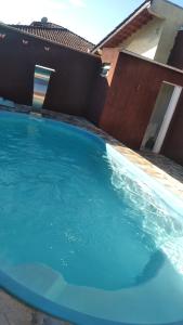 a large blue swimming pool in front of a house at Linda Casa de Praia com Piscina em Itapoá in Itapoa