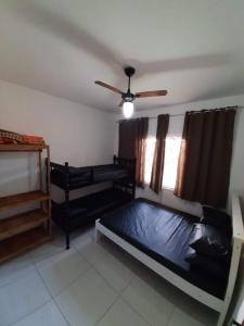 a bedroom with two bunk beds and a ceiling fan at Linda Casa de Praia com Piscina em Itapoá in Itapoa +11 photos