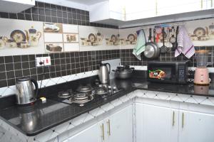 eine Küche mit Herd und Mikrowelle in der Unterkunft White House II in Naivasha + 14 Fotos