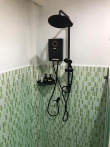 een douche in een badkamer met groene tegels bij สมายด์ ฮ่อมนา เรสเฮาท์ Smile Homna Resthouse in Ban Mae Chong