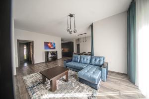 ein Wohnzimmer mit einem blauen Sofa und einem Tisch in der Unterkunft Kintu Perlas Villa - with optional Hot Tub on request in Kintai