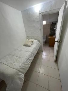 ein kleines Bett in einem kleinen Zimmer mit Bad in der Unterkunft Casa ubicada en Calle 16 Balneario Buenos Aires in Balneario Buenos Aires + 4 Fotos