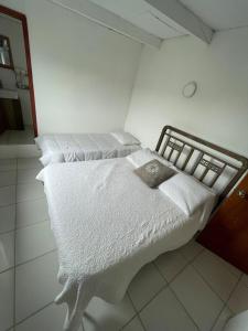 ein Schlafzimmer mit zwei Betten mit weißer Bettwäsche in der Unterkunft Casa ubicada en Calle 16 Balneario Buenos Aires in Balneario Buenos Aires
