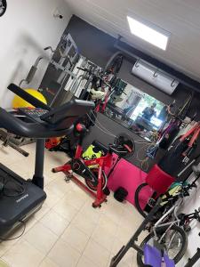 ein Zimmer mit einem Fitnessraum mit Fahrrädern und einem Laufband in der Unterkunft Casa ubicada en Calle 16 Balneario Buenos Aires in Balneario Buenos Aires