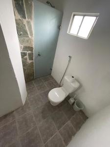 ein Badezimmer mit Toilette und Fenster in der Unterkunft Casa ubicada en Calle 16 Balneario Buenos Aires in Balneario Buenos Aires